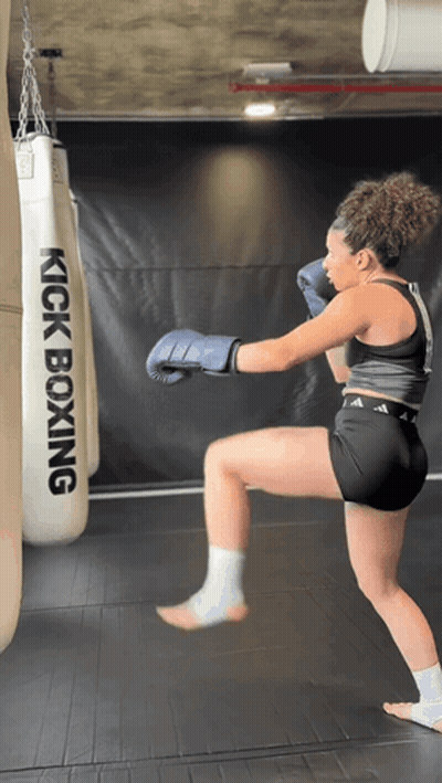 Woman In Boxing Gloves Kicking Kickboxing Bag GIF