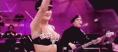 Woman In Bra Dancing While Man Plays Guitar GIF