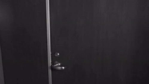 Woman In Bra Standing By Door GIF