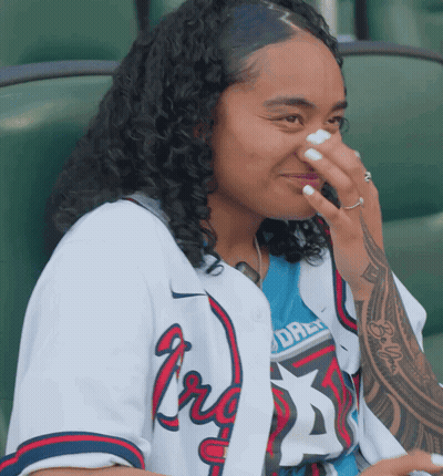 Woman In Braves Jersey Covering Nose GIF