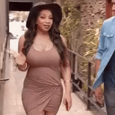 Woman In Brown Dress And Hat Walking Next To Man GIF
