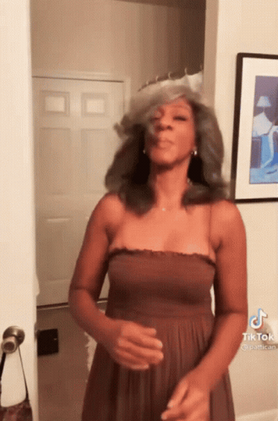 Woman In Brown Dress Making Funny Face At Door GIF