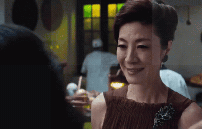 Woman In Brown Dress Smiling With Brooch GIF