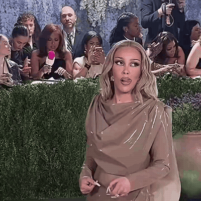 Woman In Brown Dress Standing Before Crowd GIF