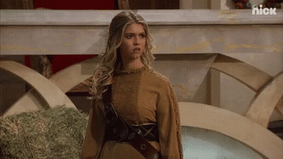 Woman In Brown Dress Standing In Front Of Hay Pile GIF
