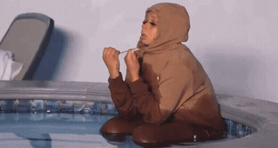 Woman in Brown Hoodie Kneeling in Pool