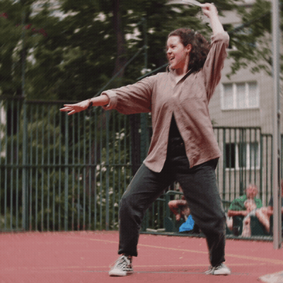 Woman In Brown Shirt And Black Jeans Dancing GIF
