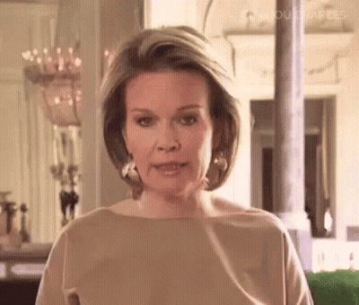 Woman In Brown Shirt And Earrings Talking GIF