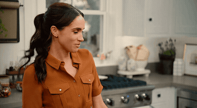 Woman In Brown Shirt In Kitchen GIF