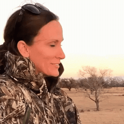 Woman In Camo Jacket And Sunglasses In Field GIF