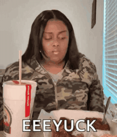 Woman In Camo Jacket Drinking From Red Straw GIF