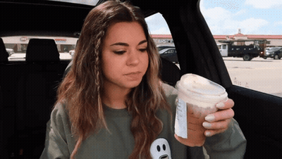 Woman In Car Holding Coffee Cup With Big O Logo GIF