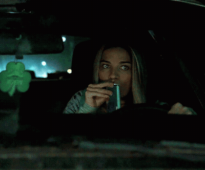 Woman In Car With Shamrock Hanging From Rear View Mirror GIF