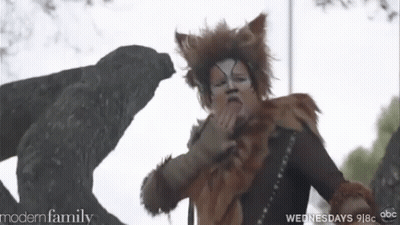 Woman In Cat Costume Standing In Front Of Statue GIF