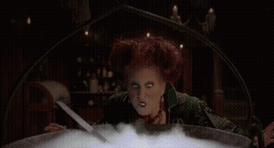 Woman In Cauldron Blowing Green Smoke GIF