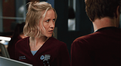 Woman In Chicago Medical Center Scrub Looking At Man GIF