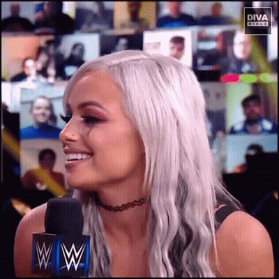 Woman In Choker Smiling In Front Of Diva Banner GIF