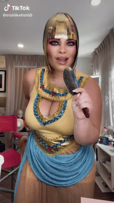 Woman In Cleopatra Costume Holding Brush GIF
