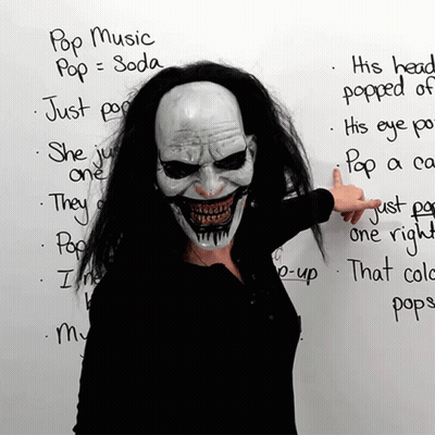 Woman In Clown Mask Pointing To Pop Music List GIF