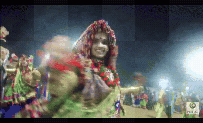 Woman In Colorful Costume Dancing Before Crowd With Portal GIF
