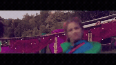 Woman In Colorful Costume Dancing In Front Of Tent GIF