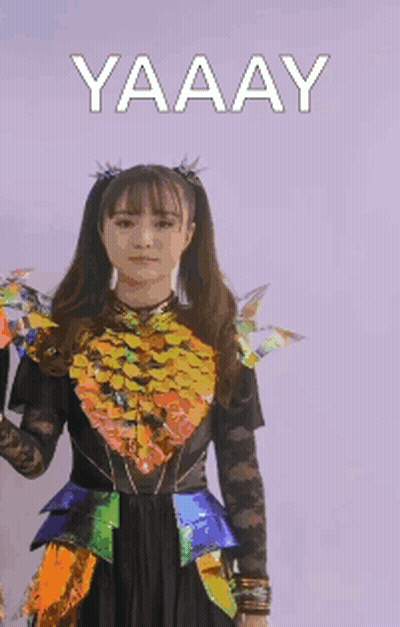Woman In Colorful Costume Raising Fist Saying Yaaay GIF