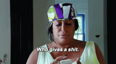 Woman In Colorful Hat Holding Cell Phone Saying Who Gives A Shit GIF