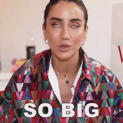 Woman In Colorful Jacket Making Funny Face Saying So Big GIF