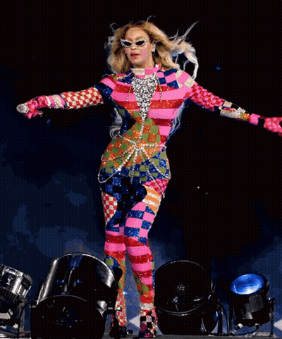 Woman In Colorful Outfit Holding Microphone On Stage GIF