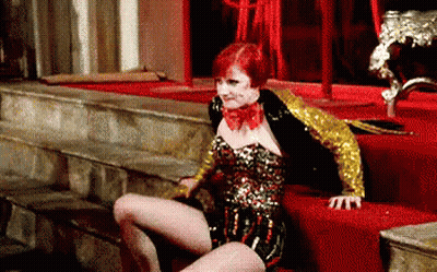 Woman In Corset And Gold Jacket On Red Carpet GIF
