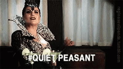 Woman In Costume Sitting At Table With Martini Saying Quiet Peasant GIF