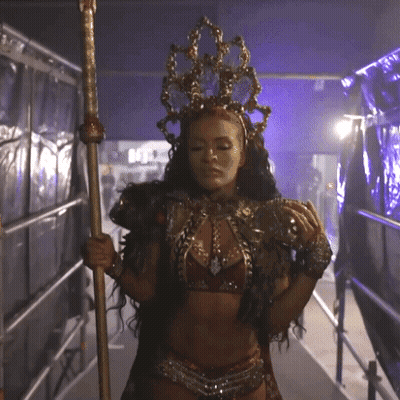 Woman In Costume With Crown Holding Pole GIF