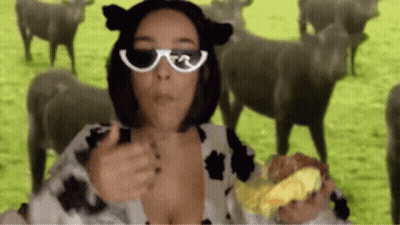 Woman In Cow Costume Holding Hamburger Before Sheep GIF