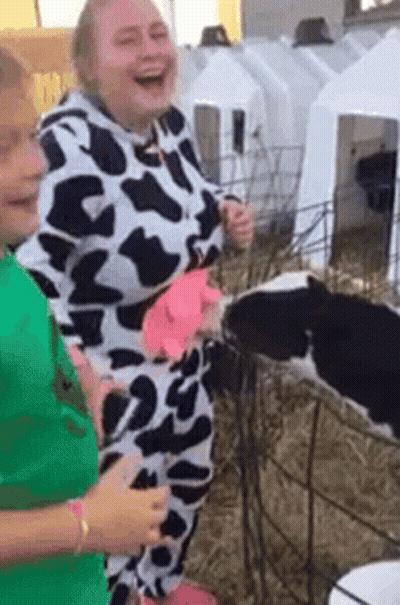 Woman In Cow Print Costume Next To Baby Cow GIF