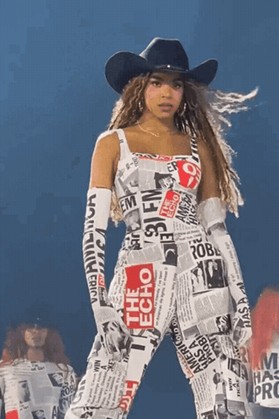 Woman In Cowboy Hat And Newspaper Jumpsuit GIF