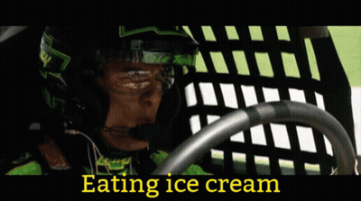 Woman In Cowboy Hat Eating Ice Cream In Front Of Racers GIF