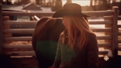 Woman In Cowboy Hat Standing Next To Horse In Stable GIF