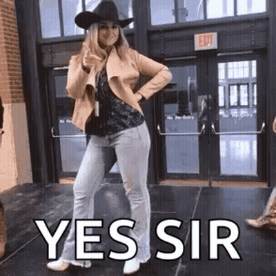 Woman In Cowboy Hat Thumbs Up Outside Building GIF
