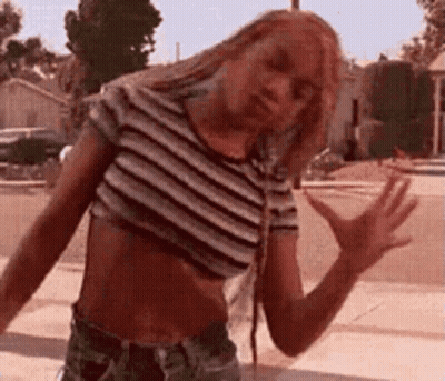 Woman In Crop Top And Shorts On Sidewalk GIF