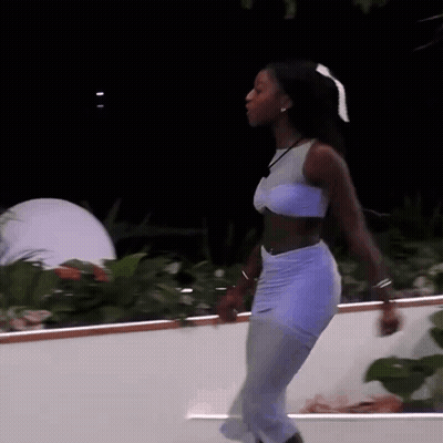 Woman In Crop Top And Skirt Dancing On Balcony GIF