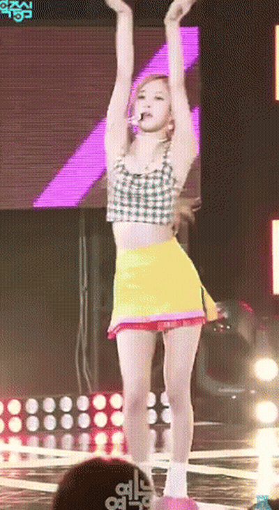 Woman In Crop Top And Yellow Skirt Dancing On Stage GIF