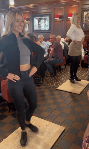 Woman In Crop Top Dancing At Tables GIF
