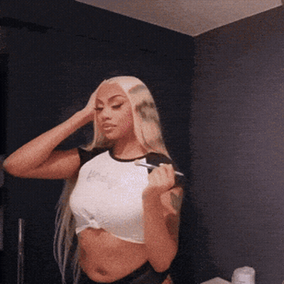 Woman In Crop Top Holding Brush Looking In Mirror GIF