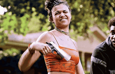 Woman In Crop Top Holding Gun Smiling GIF