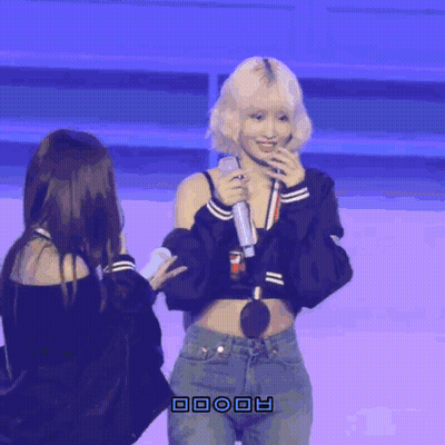 Woman In Crop Top Holding Microphone Next To Woman GIF