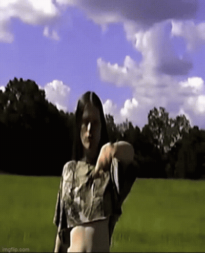 Woman In Crop Top Standing In Grassy Field GIF