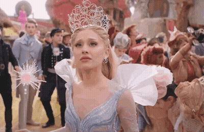 Woman In Crown Holding Wand Before Crowd GIF