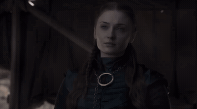 Woman In Dark Room Wearing Necklace With Circle GIF