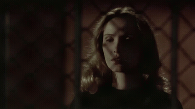 Woman In Dark Room With Hands On Neck GIF