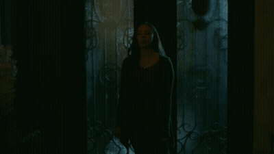 Woman In Dark Room With Wrought Iron Door GIF